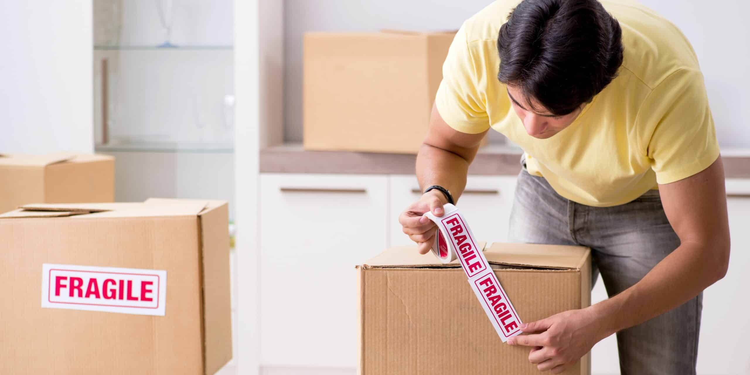 A man labeling some boxes fragile.