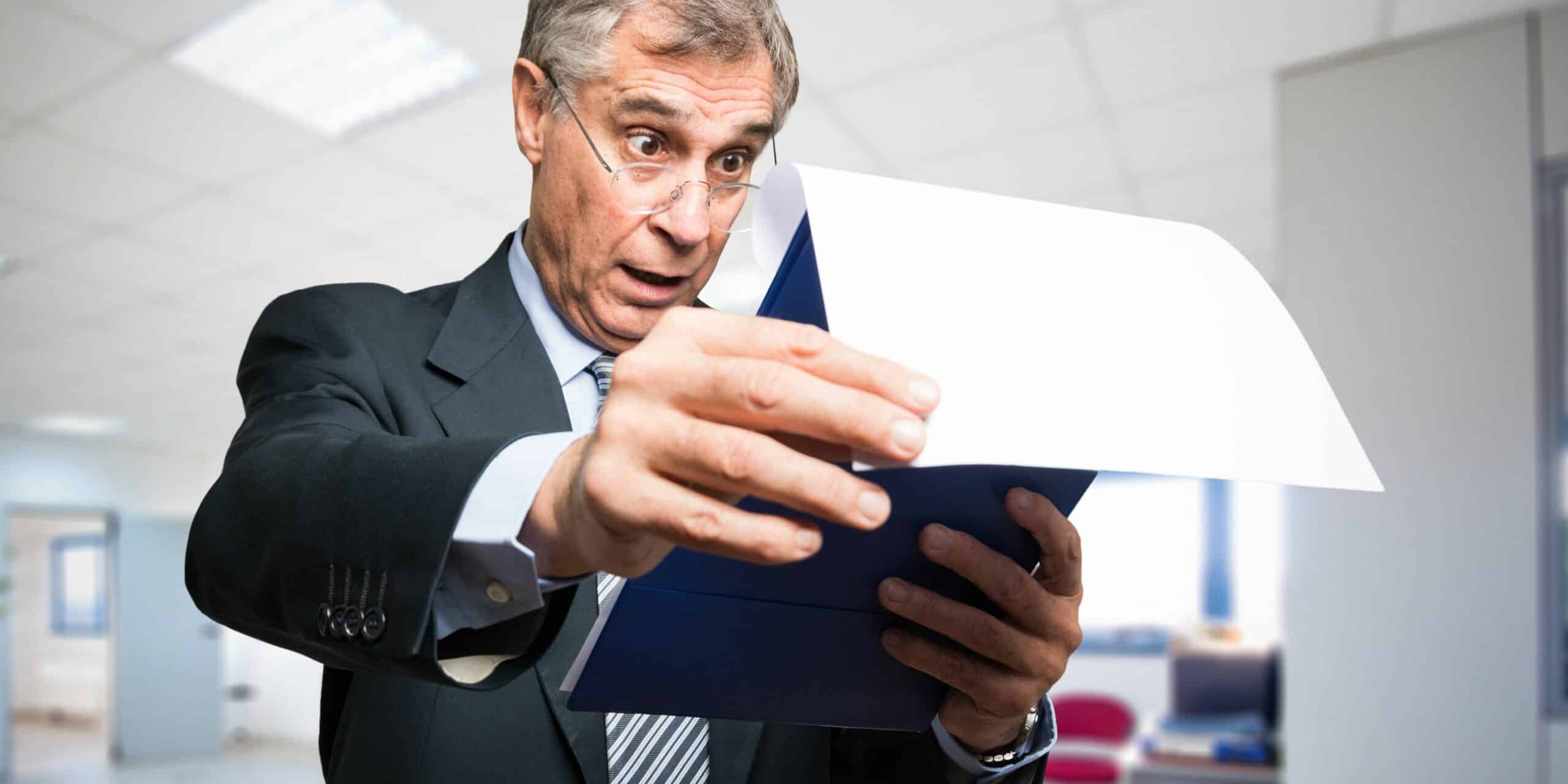 Picture of a man in shock reading a document.